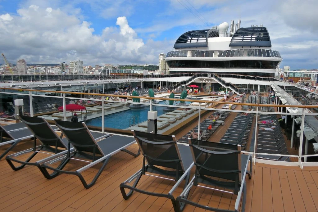 Cubierta de piscina de crucero con pasajeros disfrutando del mar — la vida a bordo combina ocio, gastronomía y entretenimiento