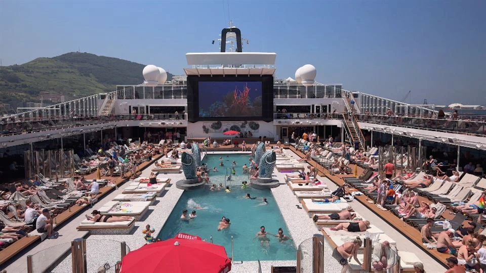 Cubierta de piscina de un crucero llena de pasajeros en un día soleado en el Mediterráneo